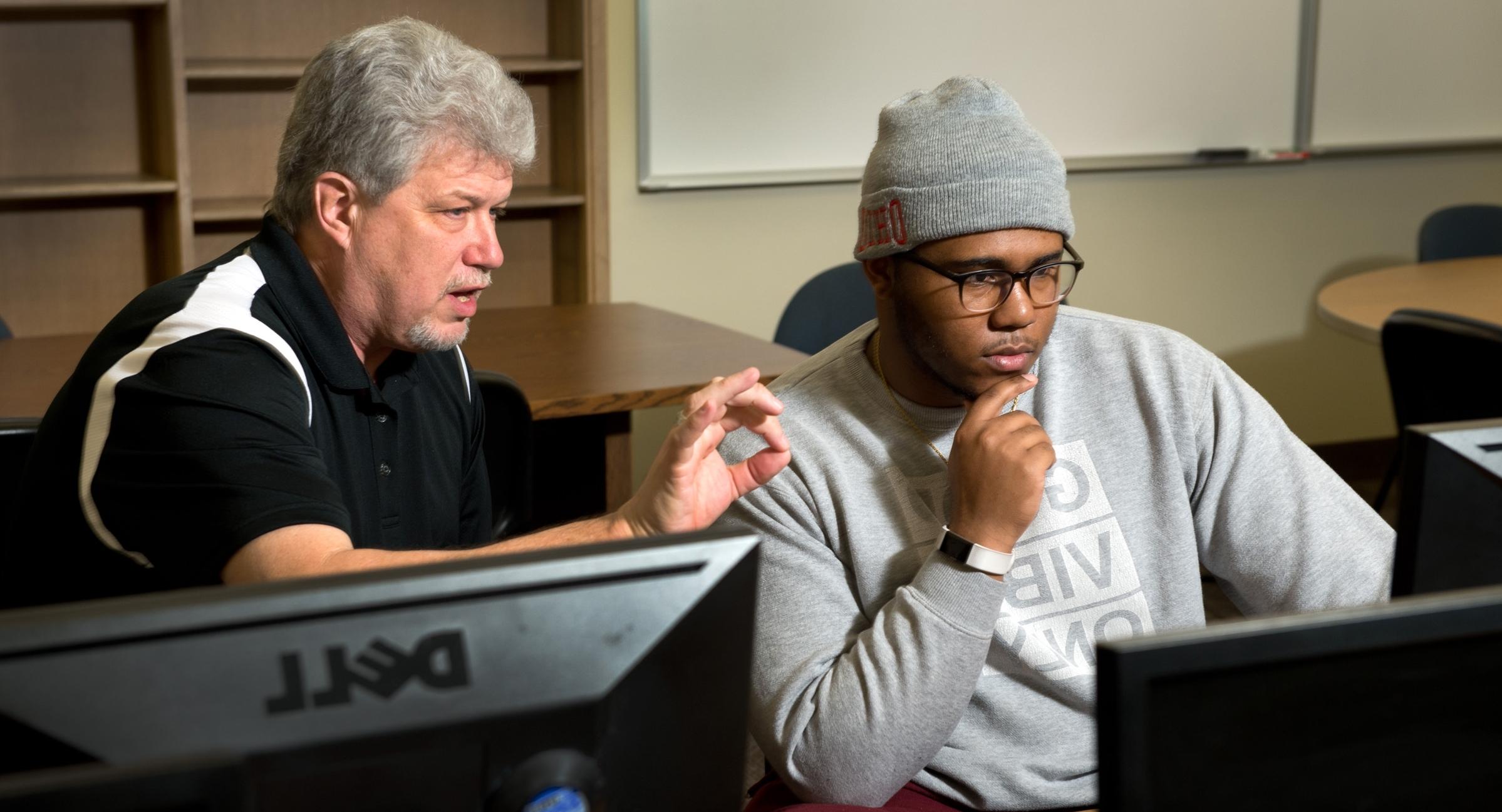 Blase Cindric with a student on a computer 