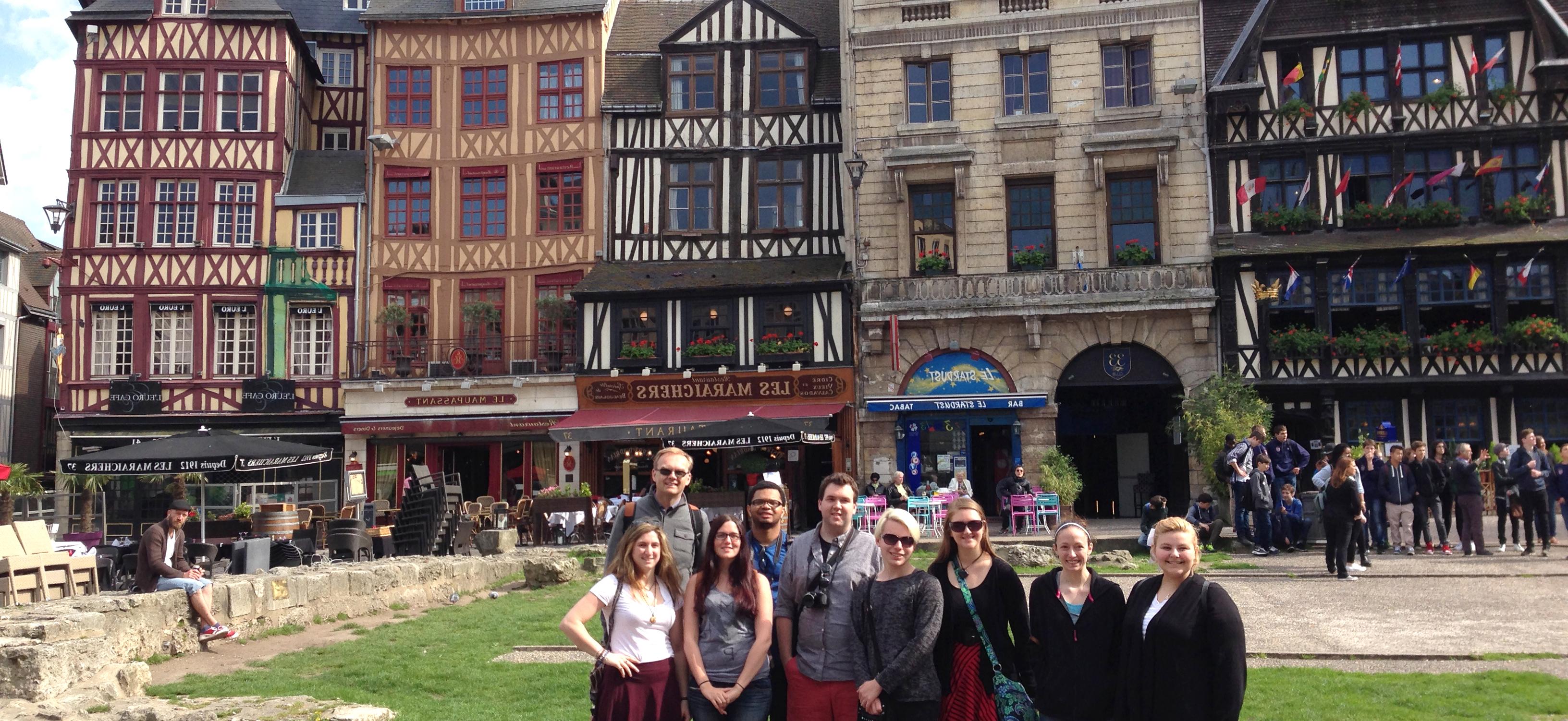 Professor with a group of students gathered in a French city